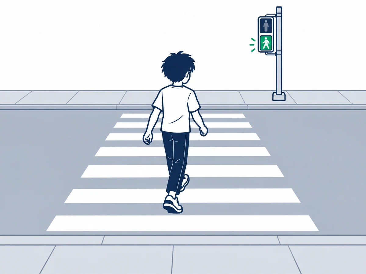 横断歩道の向こう側にある青信号に向かって渡る少年